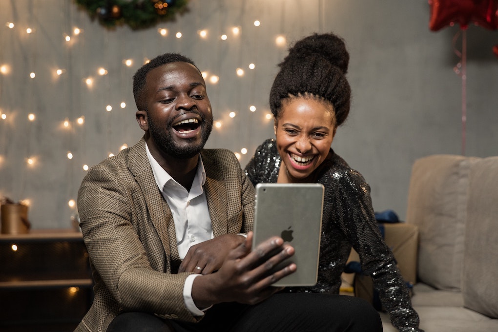 man and woman laughing in front of tablet